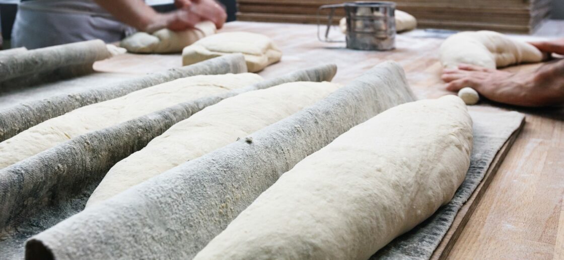 Une fois la pâte reposée, le boulanger l’a façonne pour obtenir des baguettes
