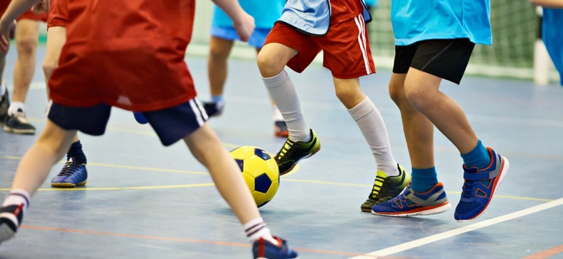 Comme au football, deux équipes adverses s’opposent dans une partie de futsal.
